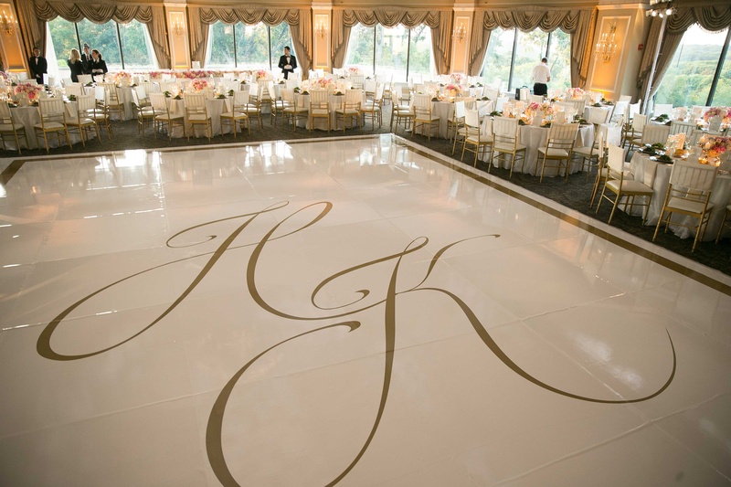 Oversized Monogram on Dance Floor
Photography: Brett Matthews Photography
Read More:
http://www.insideweddings.com/weddings/regal-outdoor-ceremony-ballroom-reception-at-oheka-castle-in-ny/821/ Wedding reception with large white dance floor gold border gold monogram with tables around Oheka