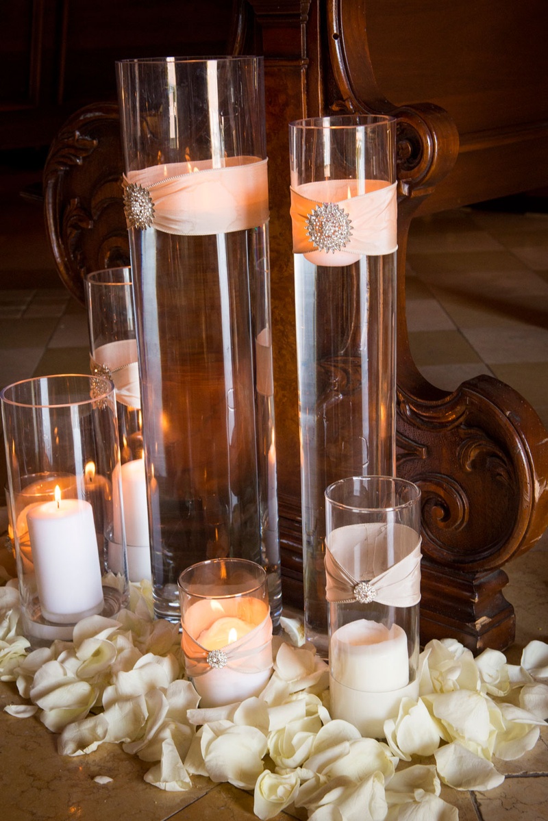Candles at the Base of Chapel Pew
Photography: Boyd Harris Photographs
Read More:
http://www.insideweddings.com/weddings/a-jeweled-floral-wedding-at-fairmont-grand-del-mar-in-san-diego/745/ Candles in hurricane vases wrapped in blush ribbon with jewel