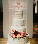 Laser-Cut Topper on Semi-Naked Cake
Photography: Joseph West Photography
Read More:
http://www.insideweddings.com/weddings/childhood-friends-say-i-do-at-garden-inspired-wedding-in-austin/1338/ semi naked wedding cake on wood table with pink orange rose dahlia flowers greenery laser cut topper