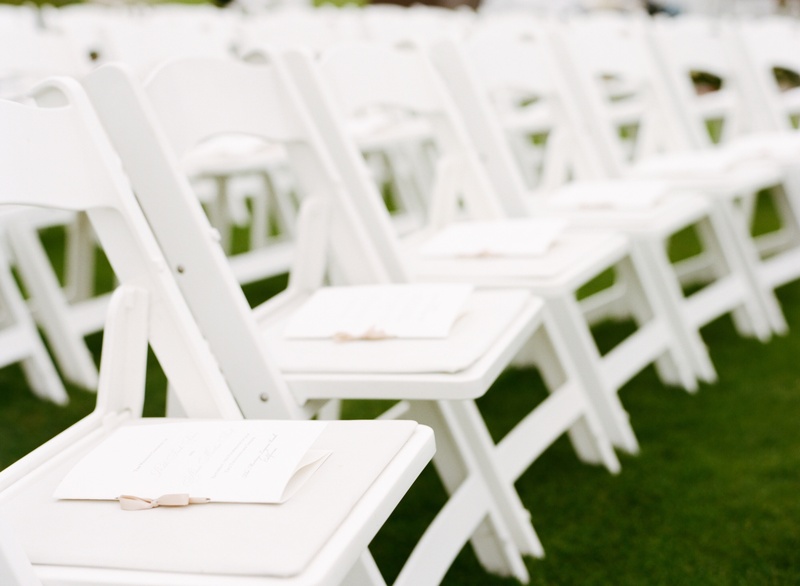 White Ceremony Chairs
Photography: Marisa Holmes
Read More:
http://www.insideweddings.com/weddings/seafoam-ivory-hued-oceanfront-wedding-in-laguna-beach-california/431/ Ribbon-tied wedding programs on each chair