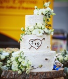 Tree Trunk Cake
Photography: Mischa Photography
Read More:
http://www.insideweddings.com/weddings/heartwarming-ranch-wedding-with-sophisticated-rustic-details/673/ White wedding cake that resembles a tree trunk, has couple's initals carved, St. Louis Rams Rampage