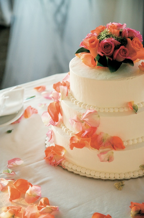 Three-Tiered White Cake
Photography: Mark Nixon Photographer
Read More:
http://www.insideweddings.com/weddings/destination-wedding-on-the-greek-island-of-santorini/207/ Ivory wedding cake topped with orange roses