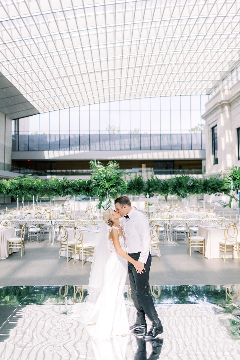 Bride %26 Groom Kiss in Reception Space
Photography: Lauren Gabrielle Photography
Read More:
http://www.insideweddings.com/weddings/summer-real-wedding-featuring-tropical-decor-at-an-art-museum/1328/ bride and groom wearing dress shirt without jacket kiss on mirror dance floor before guests arrive