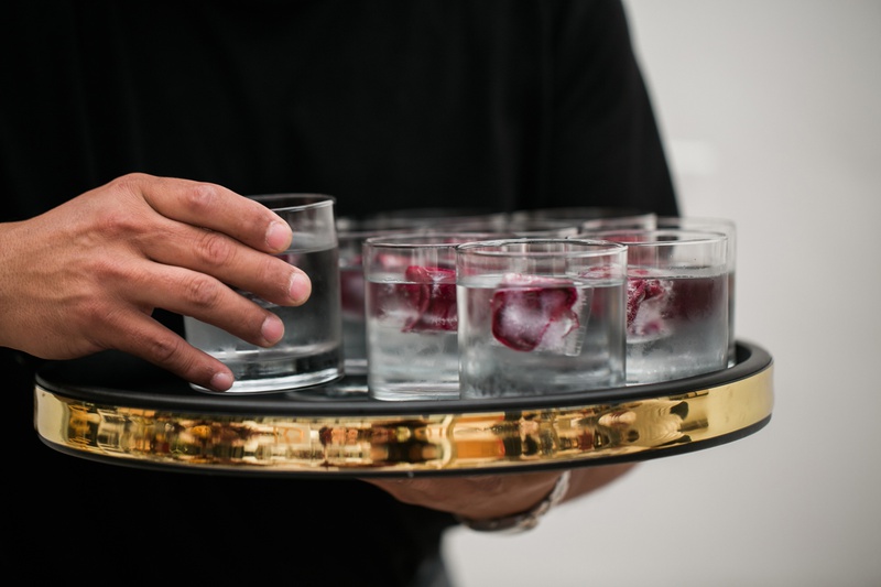 Drinks with Floral Ice Cubes
Photography: Jessica Claire Photography
Read More:
http://www.insideweddings.com/weddings/unique-chic-bridal-shower-with-dark-and-moody-color-scheme/1335/ gold border serving platter with water glasses with flower petals in ice cubs