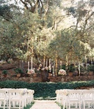 Garden Ceremony with Flower Petal Aisle
Photography: Caroline Tran
Read More:
http://www.insideweddings.com/weddings/magical-garden-ceremony-tented-reception-with-chic-french-theme/733/ Flower petal aisle at Calamigos Ranch under tree with flower arrangements hanging and twinkle lights