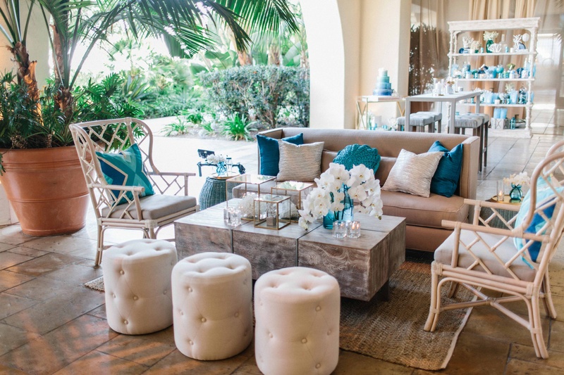 Ocean-Themed Cocktail Lounge
Photography: Braedon Photography
Read More:
http://www.insideweddings.com/weddings/orthodox-jewish-wedding-with-outdoor-ceremony-inspired-by-the-sea/812/ Wedding reception lounge for cocktail hour with blue pillows, orchids, tufted ottoman pouf, rattan