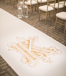 Gold Monogram on Custom Aisle Runner
Photography: John Cain Photography
Read More:
http://www.insideweddings.com/weddings/classic-wedding-with-personalized-details-and-a-pink-gold-palette/1345/ wedding ceremony gold chiavari chairs floating candles white aisle runner gold monogram