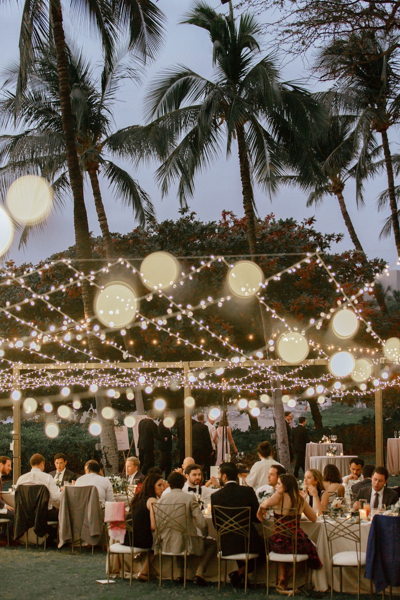 Guests at Outdoor Hawaii Wedding
Photography: Chris J. Evans Photography
Read More:
http://www.insideweddings.com/weddings/outdoor-winter-ceremony-and-reception-on-the-big-island-in-hawaii/1306/ wedding reception outside palm trees string lights gold chameleon chair collection seats dusk shot
