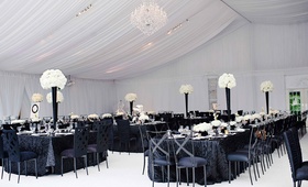 Modern Black %26 White Tented Reception
Photography: Kortnee Kate
Read More:
http://www.insideweddings.com/weddings/black-and-white-modern-wedding-with-unique-details-in-cincinnati/698/ White tent with flower centerpieces and black linens and chairs