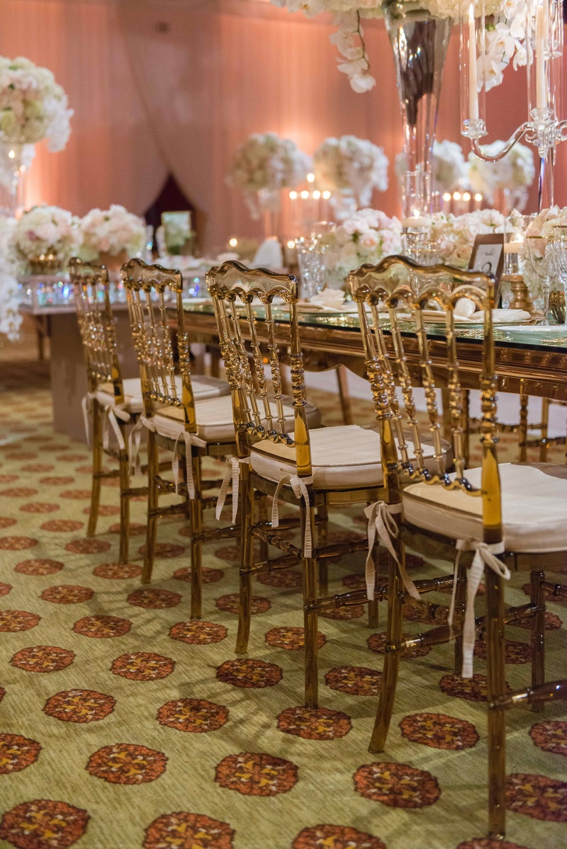 Amber Translucent Reception Chairs
Photography: The Yodsukars
Read More:
http://www.insideweddings.com/weddings/glam-10th-wedding-anniversary-party-vow-renewal-in-california/917/ Gold amber wedding chairs with ivory cushions tied around mirror long rectangle table