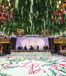 Vibrant Dance Floor with Ceiling Installation
Photography: Kent Drake Photography
Read More:
http://www.insideweddings.com/weddings/bright-and-colorful-wedding-palette-with-ceremony-overlooking-lake/1315/ white dance floor painted with floral watercolor and pink initials, lush floral ceiling installation