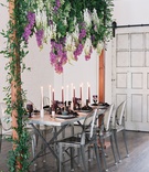 Wood Arch with Wisteria Over Table
Photography: Laura Gordon
Read More:
http://www.insideweddings.com/weddings/inspirational-spring-fete-with-moody-florals-modern-details/1182/ wedding table silver ghost chairs tall candles wisteria purple white greenery wood arch industrial