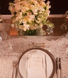 White Linens and Plateware with Low Floral Arrangement
Photography: Ira Lippke Studios
Read More:
http://www.insideweddings.com/weddings/chic-classic-new-york-city-wedding-with-personal-touches/783/ white table linens and china plateware with low white floral arrangements on mirror stand