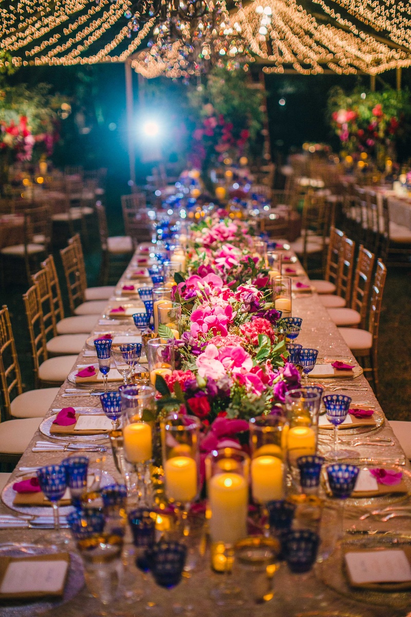 Pink Floral Table Runner on Head Table
Photography: Mi Belle Photographers
Read More:
http://www.insideweddings.com/weddings/colorful-outdoor-wedding-with-supper-club-theme-in-los-angeles-ca/741/ Head table at wedding with candlelight, pink flowers, blue goblets, and twinkle lights overhead