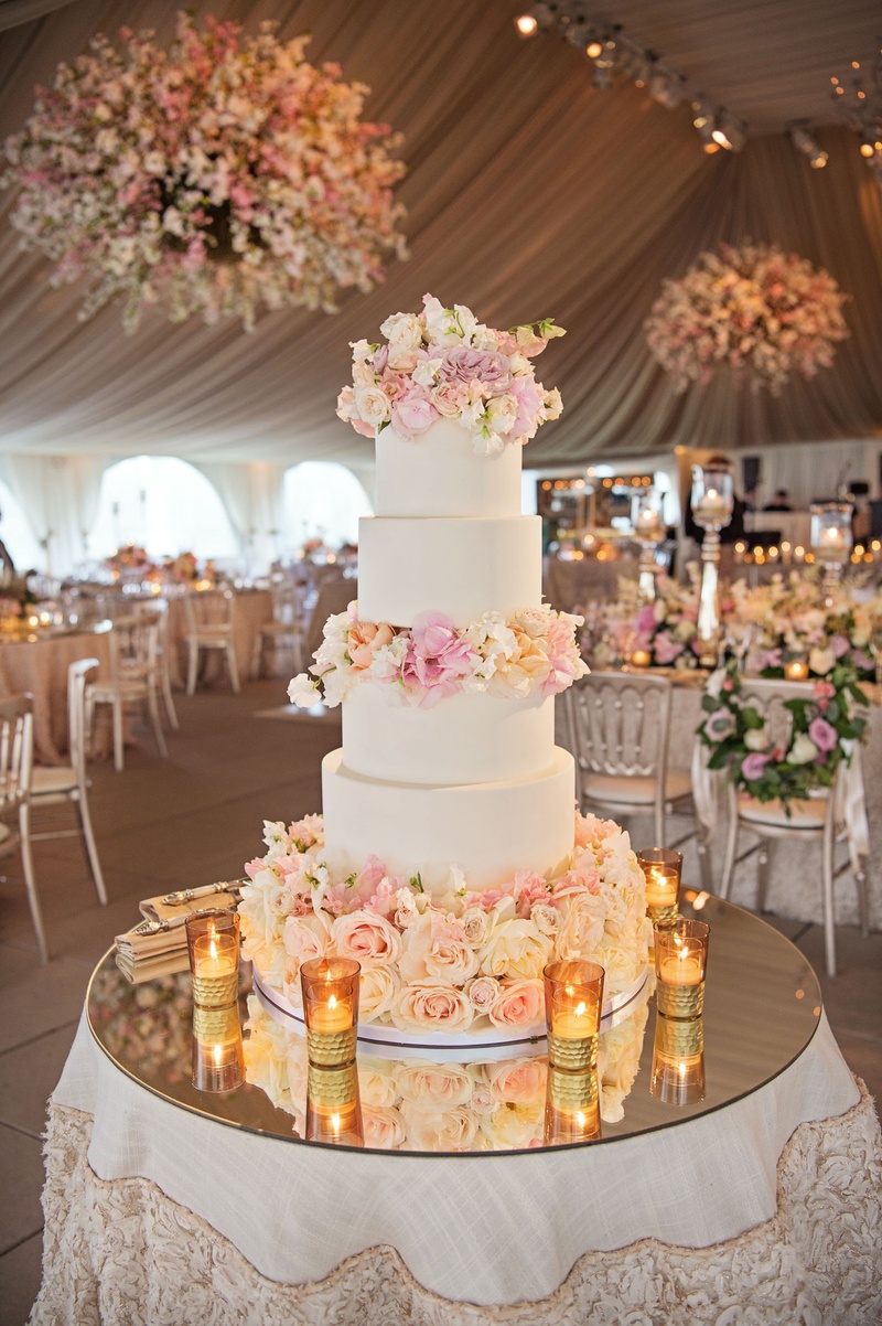 White Cake with Fresh Flower Tiers
Photography: Carasco Photography
Read More:
http://www.insideweddings.com/weddings/traditional-ceremony-glamorous-garden-inspired-tented-reception/943/ Mirror top cake table with five layer wedding cake with fresh flower layers in between