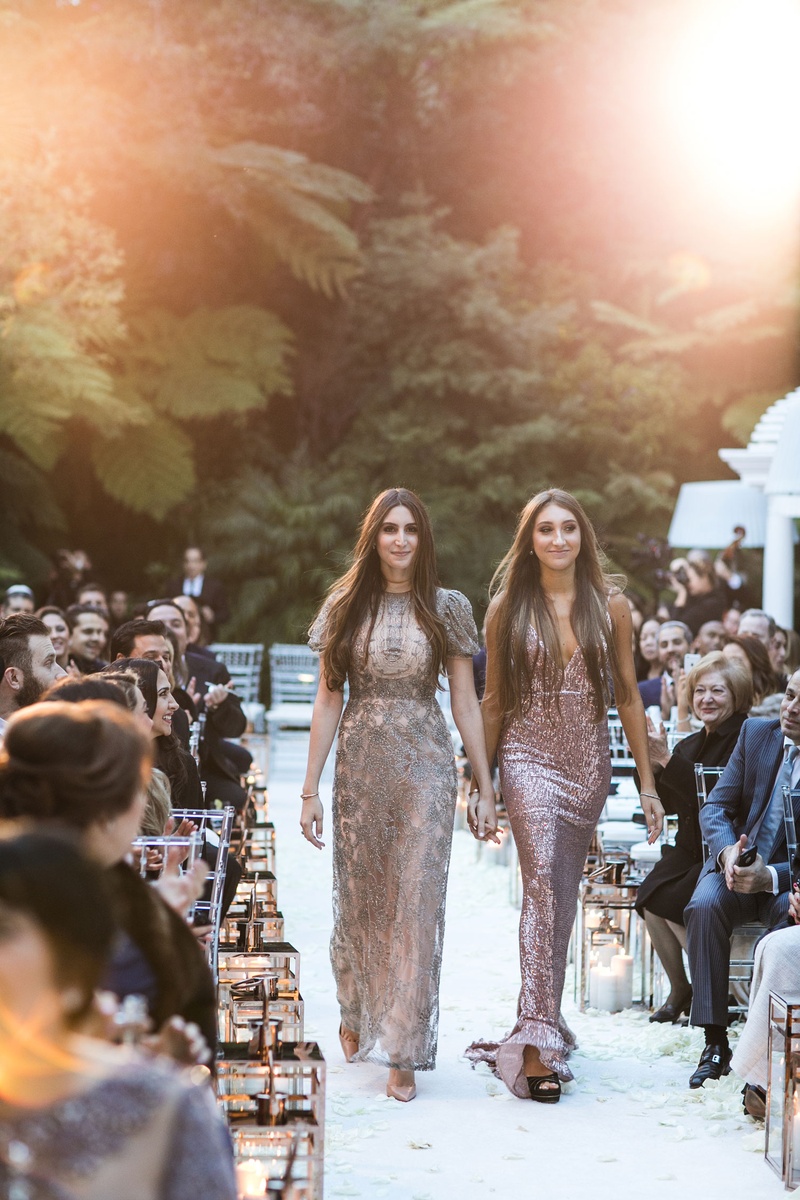 Attendants Walking Down Aisle
Photography: Samuel Lippke Studios
Read More:
http://www.insideweddings.com/weddings/glamorous-alfresco-ceremony-ballroom-reception-and-after-party/1041/ Wedding outdoor Bel-Air gold lanterns on white aisle runner bridesmaids in mismatched metallic gowns