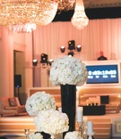 Gold, Black %26 White NYE Reception
Photography: Rob and Wynter Photography
Read More:
http://www.insideweddings.com/weddings/mlb-players-white-black-gold-nye-ballroom-wedding-in-atlanta/806/ Chandelier and countdown next to round wedding table with white rose flowers in black and gold vases