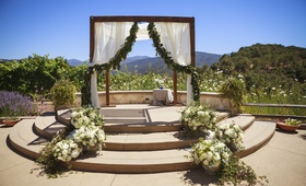 Alfresco Jewish Ceremony
Photography: Mischa Photography
Read More:
http://www.insideweddings.com/weddings/heartwarming-ranch-wedding-with-sophisticated-rustic-details/673/ Rustic wedding chuppah with garland on fabric at ranch