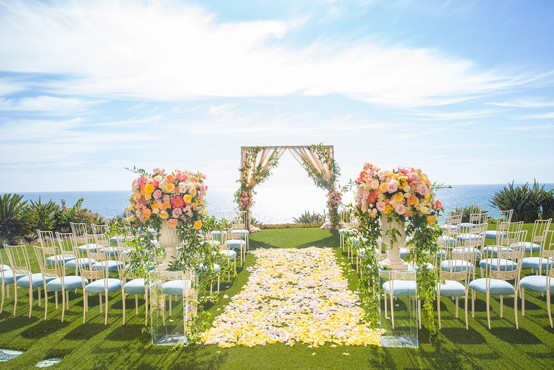 Ocean-View Pastel Wedding Ceremony
Photography: Ashley Paige Photography
Read More:
http://www.insideweddings.com/weddings/romantic-ocean-view-ceremony-charming-reception-in-california/1337/ outdoor wedding ceremony yellow flower petal aisle light blue guest seating chameleon chair