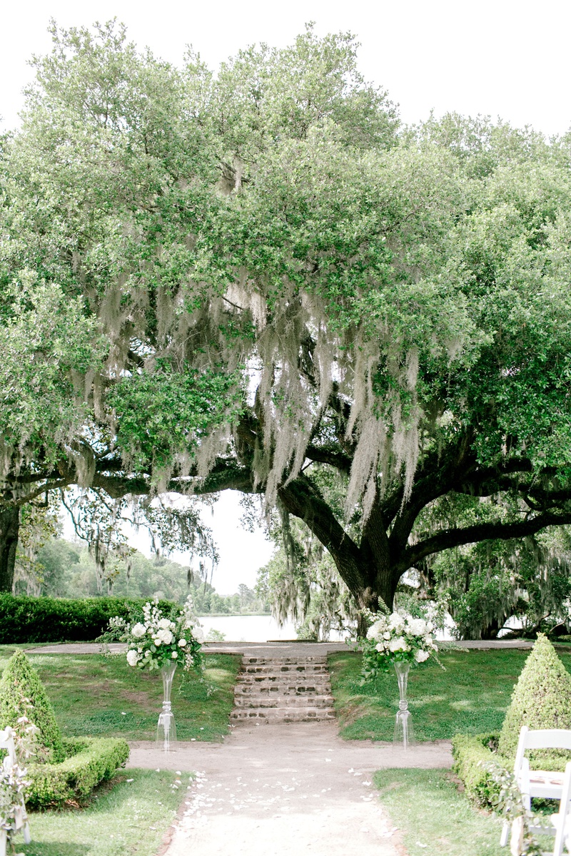 Wedding Ceremony Under Large Tree
Photography: Jennings King Photography
Read More:
http://www.insideweddings.com/weddings/alfresco-spring-destination-wedding-in-charleston-south-carolina/1277/ wedding ceremony in south carolina white flower greenery on both sides of vow exchange spot shrubs