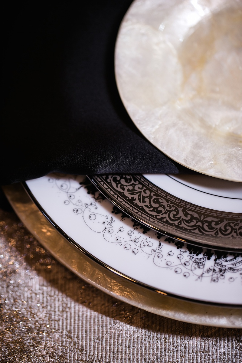 Eye-Catching Metallic Place Setting
Photography: Gold Grid Studios
Read More:
http://www.insideweddings.com/weddings/celebratory-wedding-shoot-with-elegant-romantic-decor-in-chicago/728/ Wedding reception place setting with pearl charger, dessert plate, white china with party scene