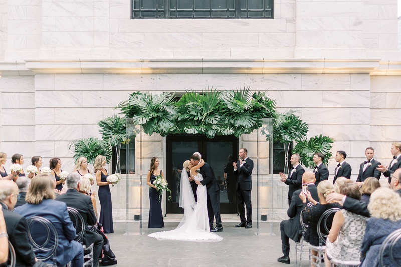 Bride %26 Groom Kiss Under Tropical Arch
Photography: Lauren Gabrielle Photography
Read More:
http://www.insideweddings.com/weddings/summer-real-wedding-featuring-tropical-decor-at-an-art-museum/1328/ cleveland museum of art wedding ceremony tropical greenery arch modern decor guests oval lucite