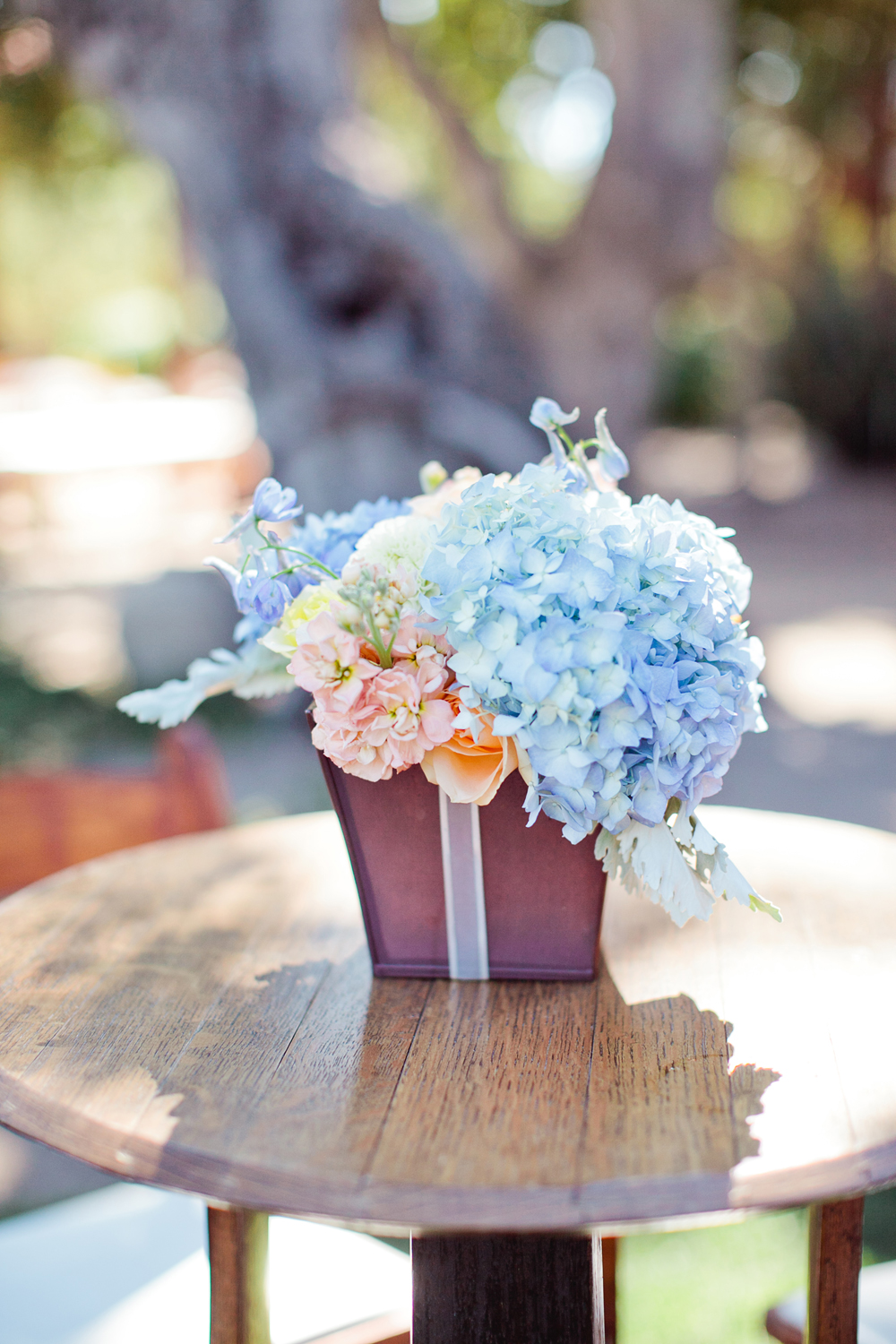 light blue hydrangea flowers on wood table at wedding cocktail table