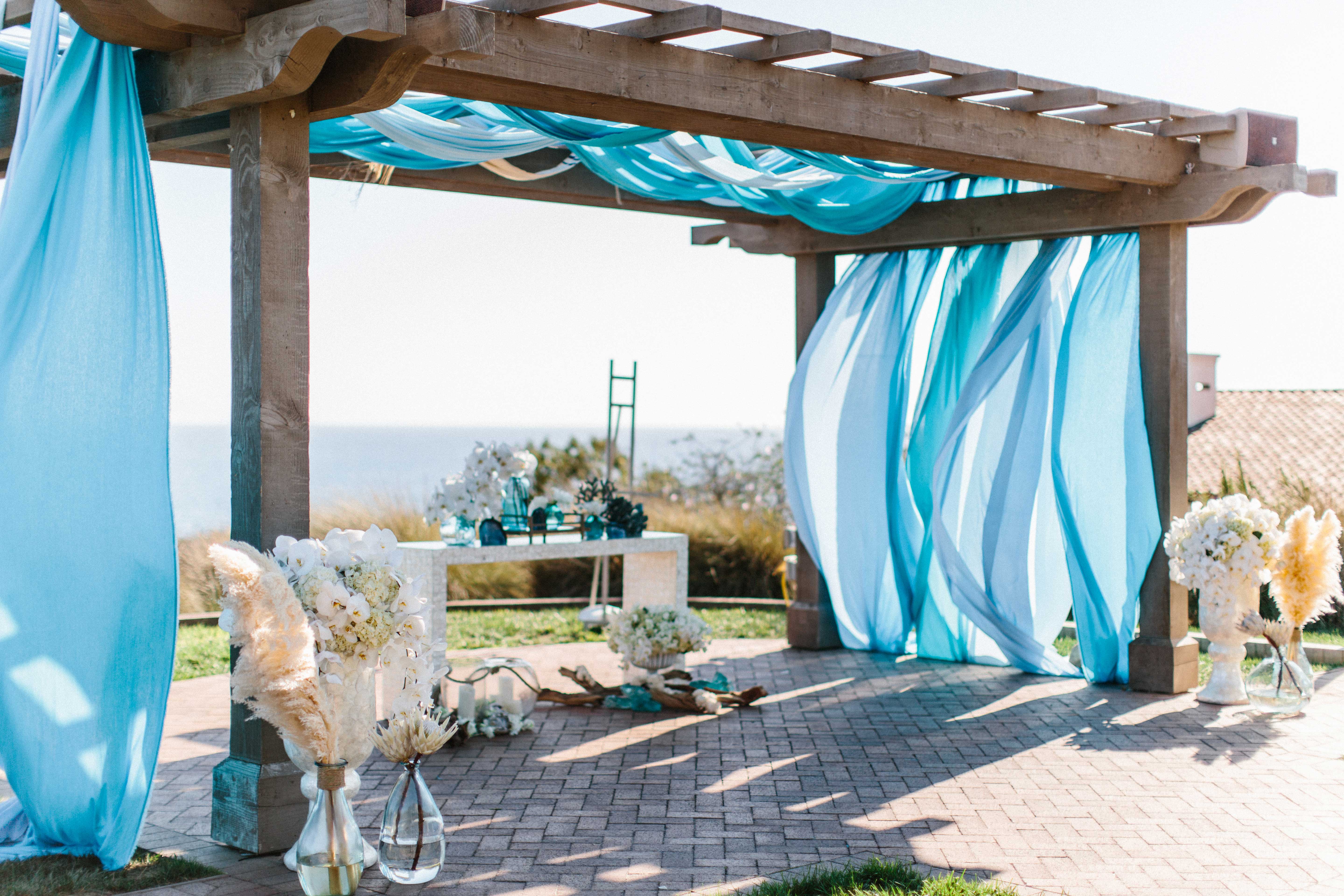beachy wedding decor ocean view wedding ceremony light blue drapery ceremony arch