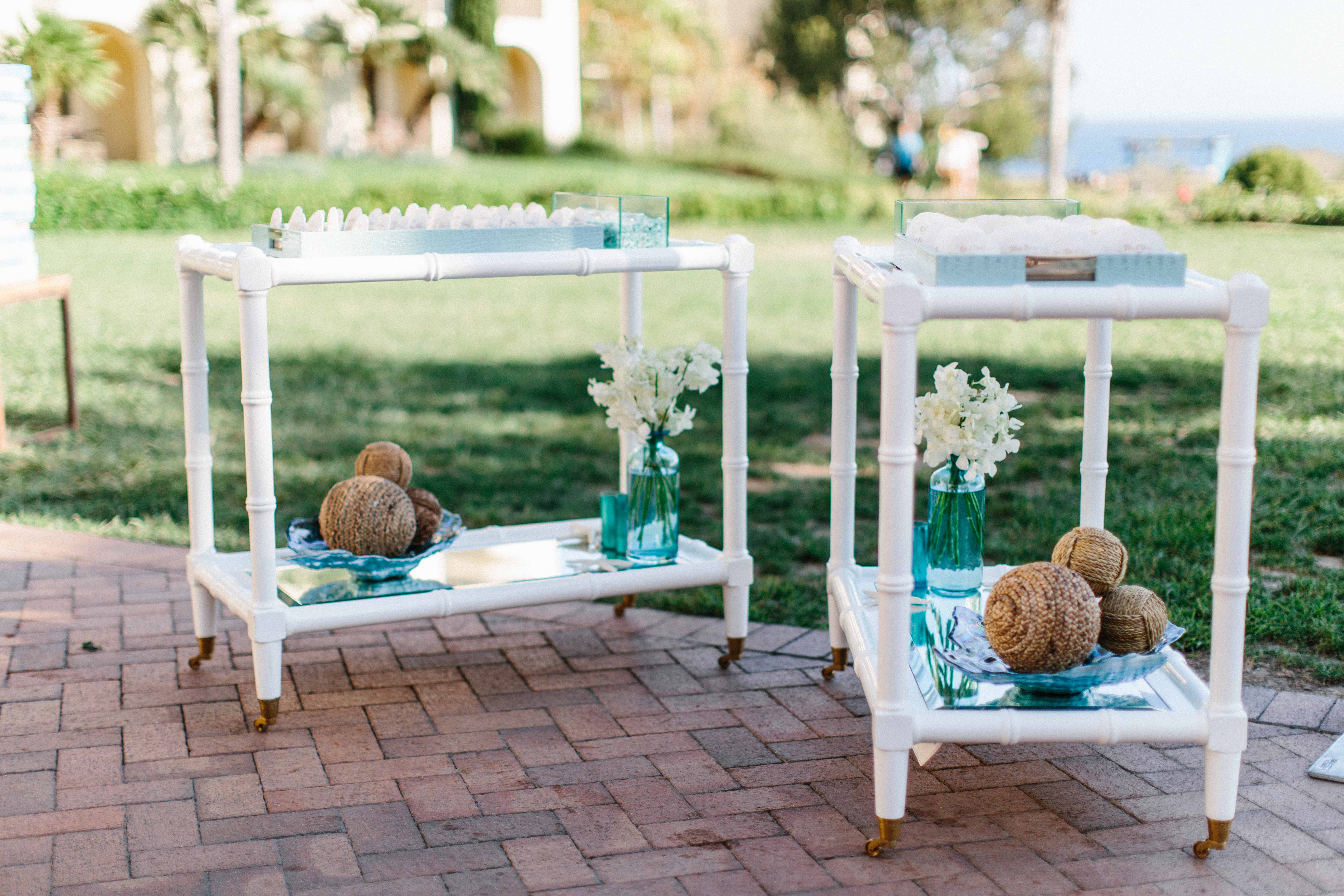 sea glass decor on bar carts at wedding ceremony and reception entrance